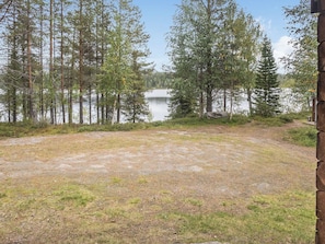 Área de cascalho com vista para um lago e árvores.