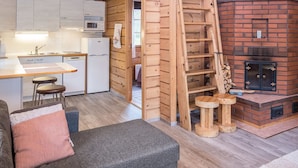 L’intérieur d’un chalet en bois chaleureux et accueillant, avec une cuisine, un coin repas et une cheminée.