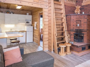 A cozy cabin interior with a kitchen, dining area, and a fireplace.