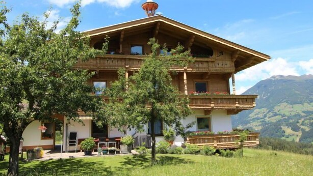 A two-story building with a balcony, surrounded by greenery and mountains in the background. - Annelies by Interhome (Aschau im Zillertal)