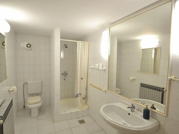 A bathroom with a toilet, a sink, a shower, and a mirror. - Apartment Maras by Interhome (Zadar)