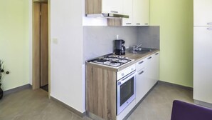 A compact kitchen with a gas stove, oven, and a coffee maker. - Vacation home Ana by Interhome (Novigrad (Zadar))