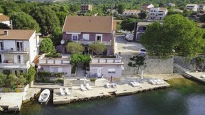 A waterfront property with a dock, lounge chairs, and a boat. - Vacation home Ana by Interhome (Novigrad (Zadar))