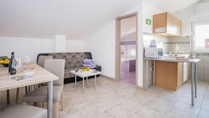 A modern apartment with a dining area, a sofa, a kitchen, and a bathroom. - Apartment B&B by Interhome (Medulin/Ližnjan)