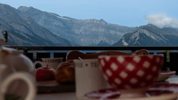 A table with a coffee setup and a view of mountains. - Vacation home Bivak by Interhome (Nendaz)