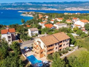 A coastal residential area with houses, a swimming pool, and a view of the sea and mountains. - Apartment Tea by Interhome (Krk/Šilo)