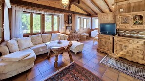 Ein Holzinnenraum mit einer Couch, einem Fernseher und Schränken.