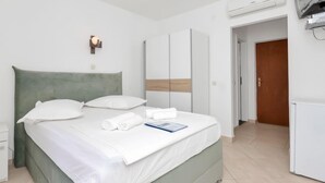 Une chambre d’hôtel équipée d’un lit, d’une télévision, d’un système de climatisation et d’une armoire.