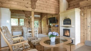 A cozy cabin interior with a dining area, a fireplace, and a television. - Kannelpirtti 1 by Interhome (Liperi)
