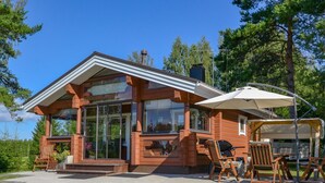A log cabin with a porch, outdoor seating, and a grill. - Kannelpirtti 1 by Interhome (Liperi)