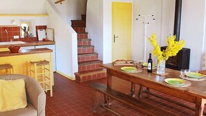 Eine gemütliche Küche mit Holztisch, gedecktem Esstisch, einer Treppe und einer gelben Tür.