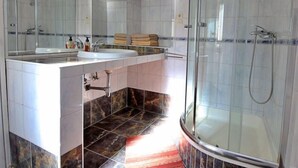 Une salle de bain moderne avec une douche à parois de verre, un meuble-lavabo et un miroir.