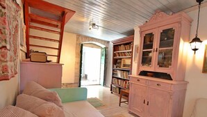 Una habitació acollidora amb un llit, un armari rosa i una prestatgeria.