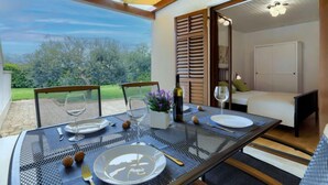 A dining table set for two with a view of the garden.