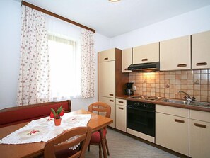 Een koelkast, een oven, kookgerei, borden en bestek