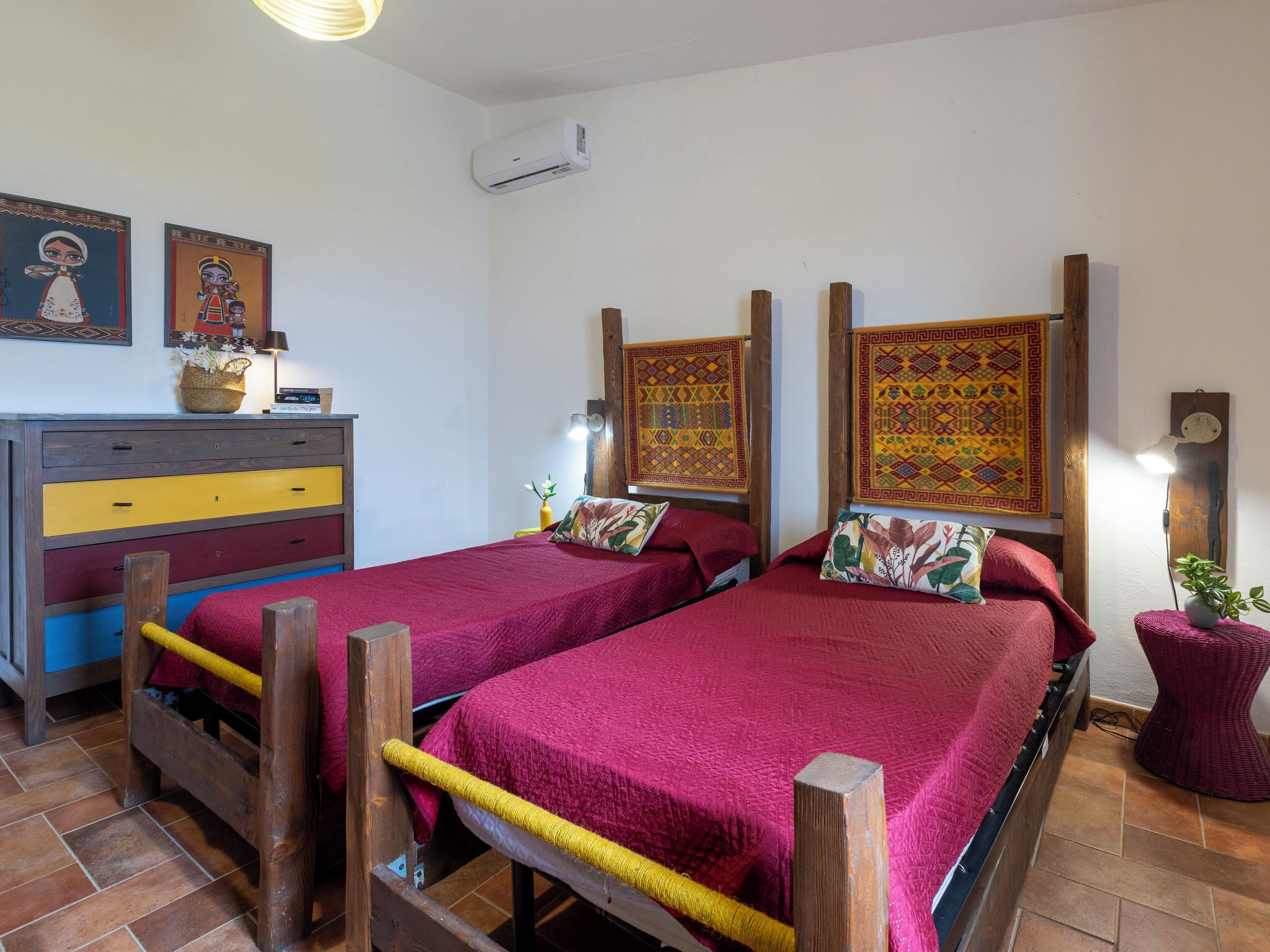 Une chambre avec deux lits, une commode et des éléments décoratifs fixés au mur.