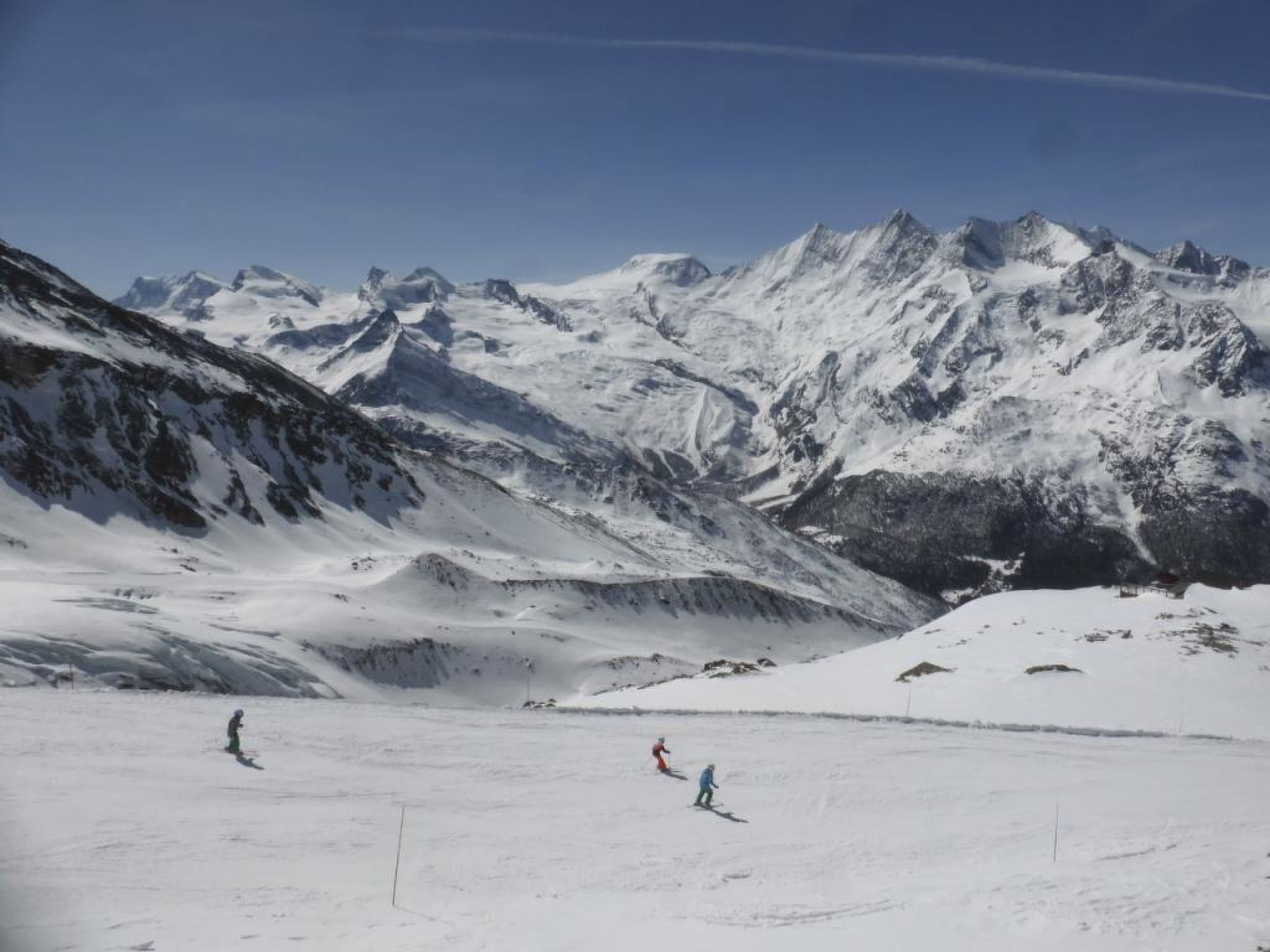 A snowy mountain landscape with skiers.