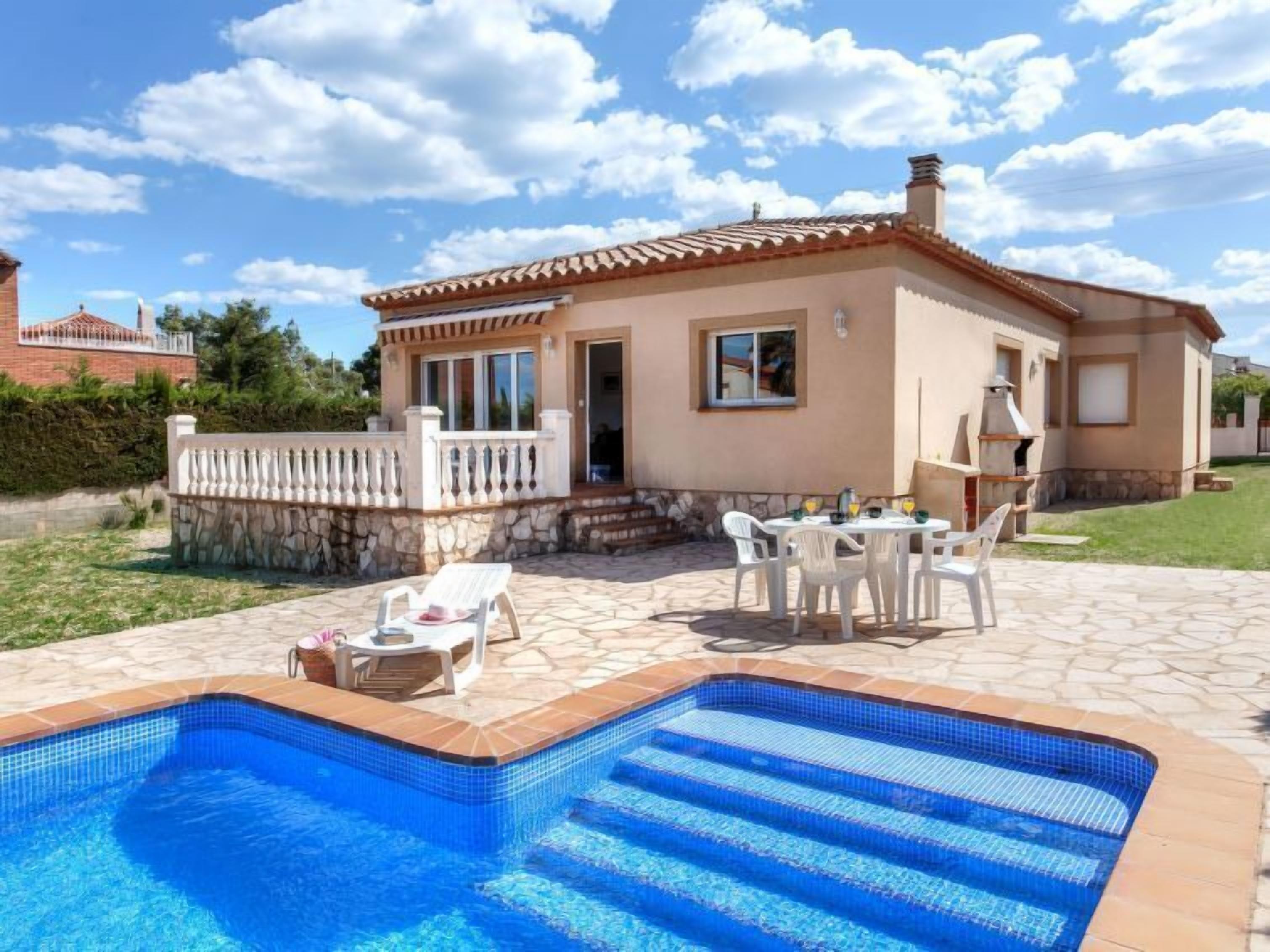 A two-story house with a swimming pool, outdoor seating, and a barbecue area.