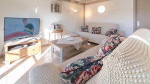 A living room with a TV, sofa, and wooden furniture. - Vissershuisje 213 with parking by Interhome (Bredene)