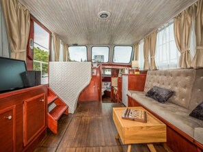 Un espacio interior acogedor con un sofá, un televisor y una mesa de centro de madera.