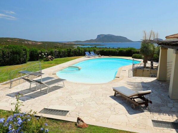 Une piscine avec vue sur la mer et une montagne en arrière-plan.