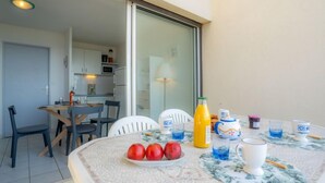 A dining area with a table set for breakfast, including apples, juice, and cups. - Le Sunset/Cap Sud by Interhome (Cap d'Agde)