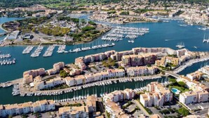 A coastal cityscape with a marina filled with boats, surrounded by residential buildings. - Le Sunset/Cap Sud by Interhome (Cap d'Agde)