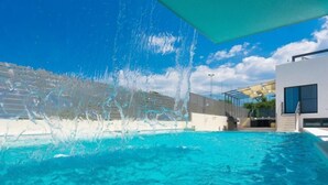 A swimming pool with a water feature, a modern building, and a clear sky. - Vacation home La Mer by Interhome (Pula)