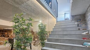 A modern interior with a concrete staircase, glass walls, and indoor plants. - Vacation home La Mer by Interhome (Pula)