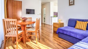 Una sala de estar moderna con una mesa de comedor de madera, un sofá azul y una mesita auxiliar.