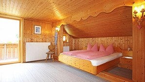 Ein Schlafzimmer einer Holzhütte mit einem Bett, einem Sessel und einer Heizung.