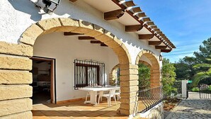 Une maison dotée d’un patio couvert, d’arcs en pierre et d’un sol carrelé.