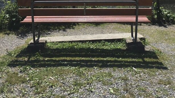 A bench by a lake with mountains in the background.