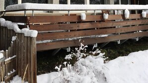 A chalet with a wooden balcony and snow-covered surroundings.