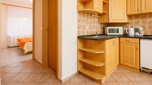 Eine kompakte Küche mit Holzausstattung, einer Mikrowelle und einer Kaffeemaschine.
