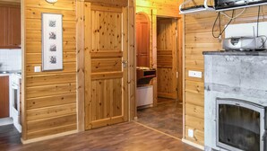 Un intérieur en bois avec une cheminée, des portes en bois et une horloge au mur.