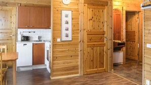 Un intérieur en bois comprenant une cuisine, un coin repas et un couloir.