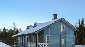 Une maison à deux étages avec un porche et une cheminée.