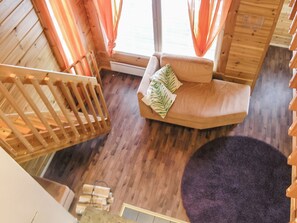 Een houten interieur met een gebogen bank, een houten stoel en een paars tapijt.