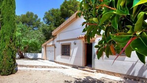 Una casa de un piso con garaje, un porche pequeño y un jardín.