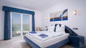 A bedroom with a large bed, a view through a sliding door to an outdoor balcony, and a painting on the wall. - Stuttgart by Interhome (Moraira)