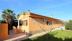 Une maison de plain-pied avec un toit en tuiles, un petit porche à l’avant et une fresque décorative représentant un dragon sur le côté.