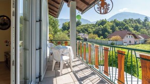 A balcony with a table and chairs, a view of a mountain, and a wooden fence. - Apartment Pacher by Interhome (Gallizien)