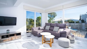 A modern living room with a grey sofa, two white round tables, and a patterned ottoman. - Casa Encinas by Interhome (Moraira)