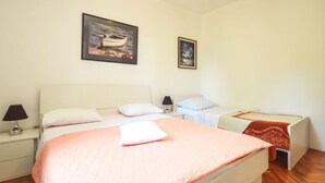 Une chambre à coucher comprenant un lit, deux tables de chevet, une commode, une lampe et deux tableaux encadrés accrochés au mur.
