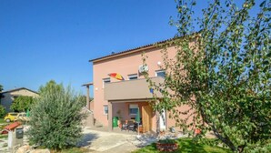 A two-story building with a flat roof, a small patio area with outdoor furniture, and a garden with rocks and shrubs. - Apartment B&B by Interhome (Medulin/Ližnjan)