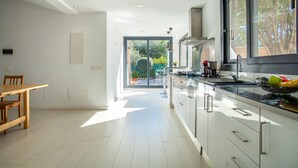 Une cuisine moderne dotée d’une grande fenêtre, d’un coin repas et offrant une vue sur l’extérieur.