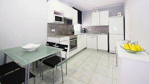 A compact kitchen with white cabinets, a microwave, a coffee maker, and a small fruit bowl on the counter. - Sant Mori by Interhome (Empuriabrava)