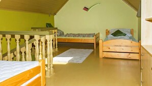 A dormitory room with two wooden beds, a wooden desk, and a bunk bed. - Cortaderia 1 by Interhome (Keszthely/Balatonkeresztur)