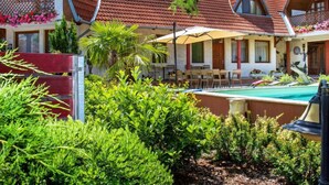 A resort with multiple chalet-style cabins, a swimming pool, and lush greenery. - Cortaderia 1 by Interhome (Keszthely/Balatonkeresztur)